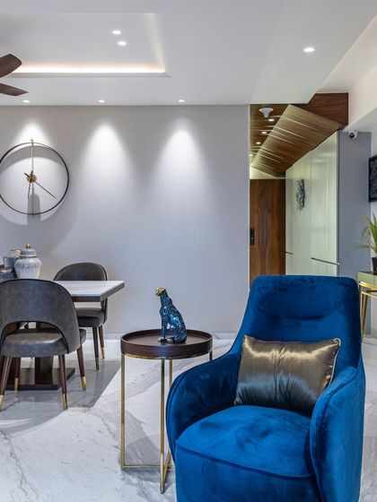 A detail shot from the Filigree House, focusing on the vibrant blue armchair. This single piece injects a burst of color and personality, demonstrating how a well-chosen accent can elevate an entire room.