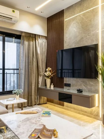 This TV unit space epitomizes understated luxury, blending rich textures with sleek functionality. The marble-clad backdrop and ambient vertical lighting emphasize elegance while creating a visually expansive effect, adding utility and fluidity to the urban sophistication of the space.