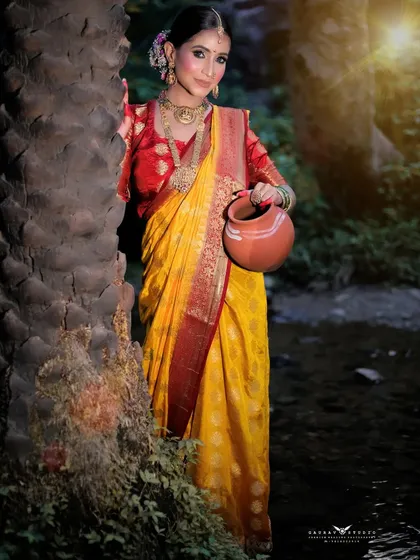 The model stands by a tree, holding a traditional pot, creating a rustic and authentic village scene.