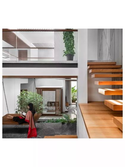 In the Janani House, I designed a multi-level space connected by floating wooden stairs and a traditional indoor swing. This creates a dynamic yet comfortable family area that encourages interaction.