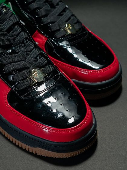 A close-up of the toe box on the Bapesta UAE edition, showing the glossy patent leather and the gold Bape lace accessory.