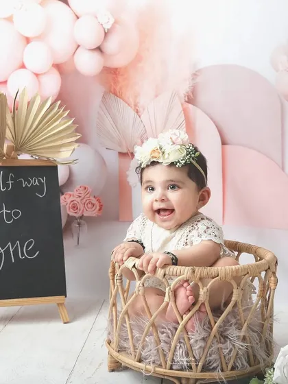 Halfway to one is a milestone worth celebrating. This adorable half-birthday shoot features a beautiful pink boho theme with a custom chalkboard sign to mark the special occasion.