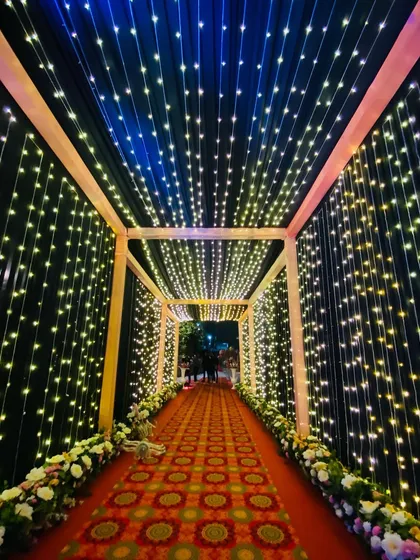 A stunning tunnel of light created with thousands of fairy lights on the walls and ceiling. The mix of warm and cool lights creates a dynamic and mesmerizing effect as guests walk through.