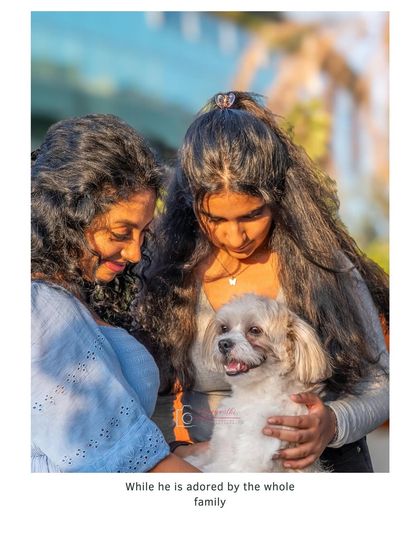 A sweet moment between two sisters and their dog, Milo. This image captures the gentle, loving atmosphere of their family photoshoot.