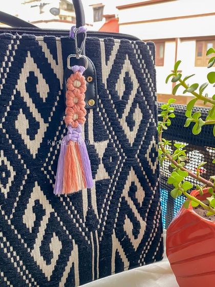 This keychain features a beautiful floral knot design, perfect for anyone who loves flowers. It's a small but intricate piece that makes a lovely, thoughtful gift.