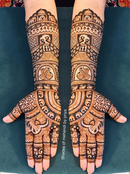 A very dense and intricate full bridal design. This pattern is filled with peacocks, elephants, and complex geometric fills for a truly grand statement.