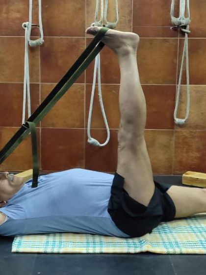 Demonstrating a supine leg stretch with a strap. This is a fundamental practice for hamstring flexibility that we often cover in online classes.