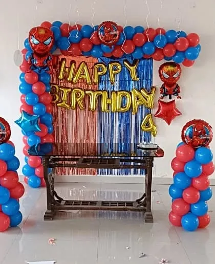 A classic Spiderman party decoration with a balloon arch, pillars, and character foil balloons.