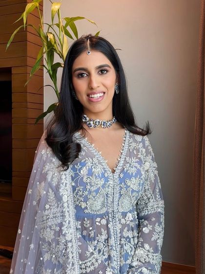 Moments of calm before a power packed baraat. The stunning sister of the groom is ready to celebrate her brother's big day with a fresh and elegant makeup look.