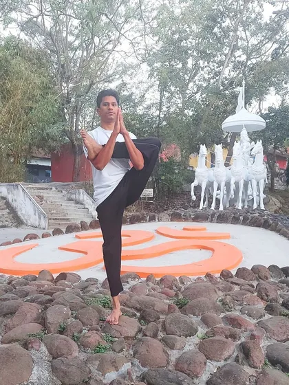 Practicing a one-legged balancing asana before the sacred symbol 'Om' reminds us of our connection to the universe. Yoga helps us build immunity not just by strengthening the body, but by reducing the stress hormones that compromise our well-being.