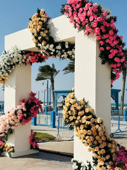 A close-up of a modern wedding arch, with flowers spiraling around the clean white structure. This is how we add a touch of romance to a contemporary beachside setting.