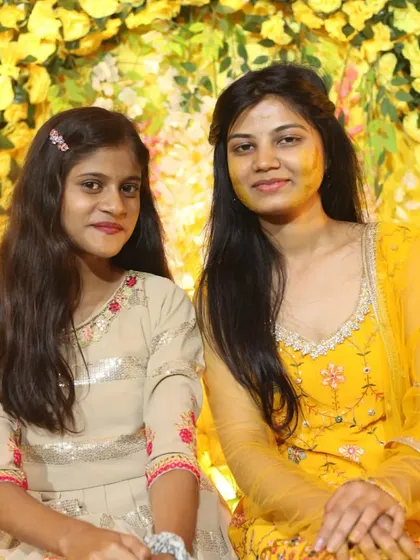 A quiet moment between two family members amidst the yellow floral backdrop of the Haldi ceremony. We capture both the high-energy and the serene moments of the day.