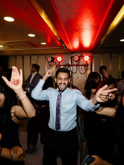 Guests enjoying themselves on the dance floor, with colorful party lights adding to the festive atmosphere.
