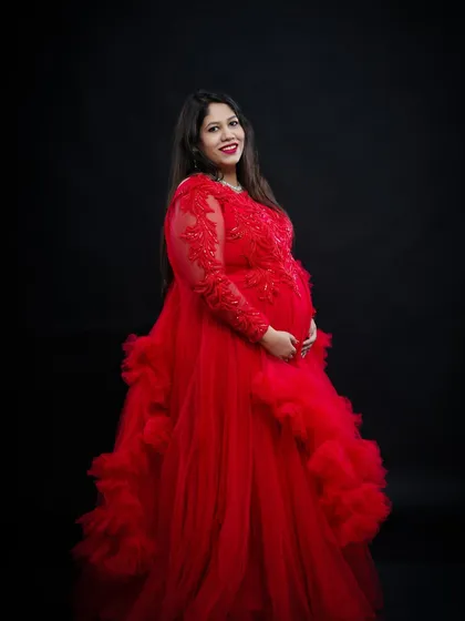 A classic solo portrait in our dramatic red gown. The long sleeves with lace detail and the voluminous skirt create a look of pure elegance against the dark backdrop.