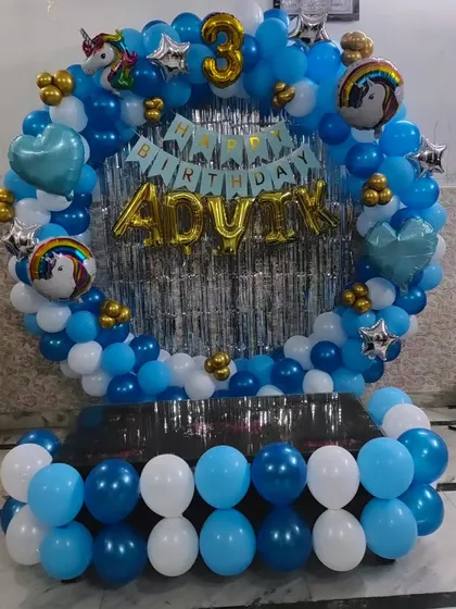A blue and white ring decoration for a 3rd birthday, with the name 'ADVIK' in gold foil letters.