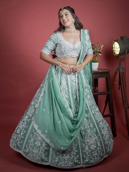 A full shot of the mint green lehenga with its unique draped dupatta. The white threadwork creates a striking contrast, offering a fresh and elegant look for any wedding celebration.