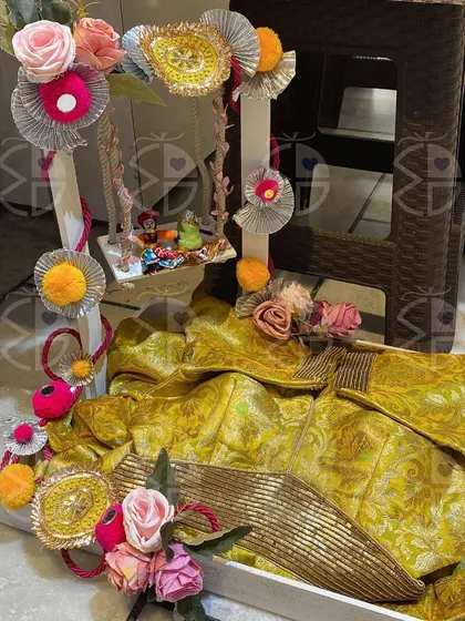 A vibrant yellow 'saree' takes center stage in this Teej hamper. The entire arrangement is designed to capture the joyful and colorful spirit of the festival.