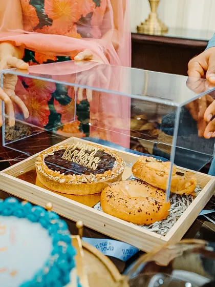 My Rakhi gift hampers are the perfect mix of sweet and savoury. This one includes a chocolate tart, bagels, and other baked goodies in a beautiful acrylic box.
