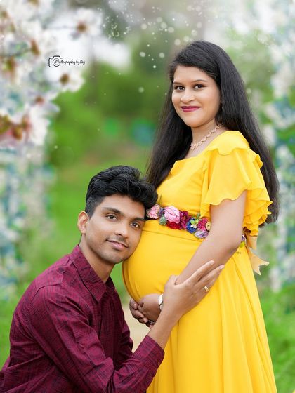 A classic couples pose, with the father-to-be listening to the baby bump. The bright yellow dress adds a cheerful touch to this outdoor maternity photo.