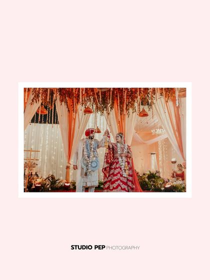 The couple during the Varmala ceremony, their joyful exchange captured under a beautifully decorated mandap.