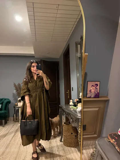 A mirror selfie in an olive green shirt dress. This is a versatile piece that can be dressed up or down.