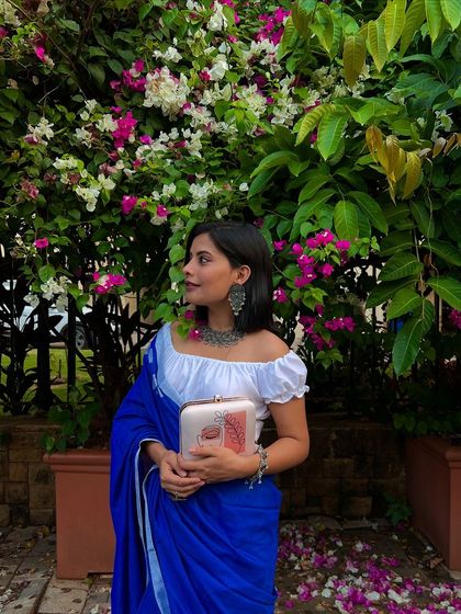 Phulkoli. This abstract line art clutch looks so dreamy paired with a simple blue cotton saree and silver jewelry.