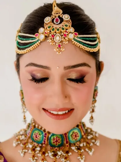 This shot highlights the client's stunning eye makeup, which is perfectly complemented by the neat and elegant bun hairstyle.