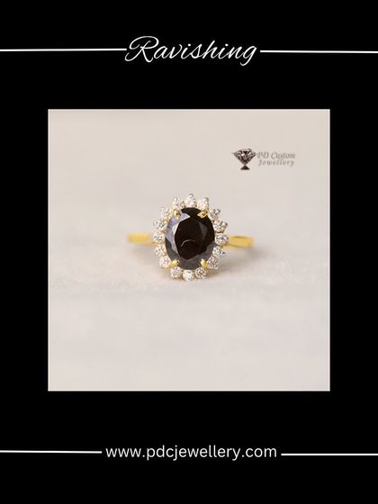A classic and ravishing design. This 18kt gold ring features a deep-colored oval gemstone surrounded by a halo of natural round diamonds, perfect for any special occasion.