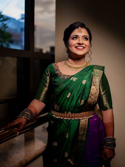 A full view of this bride's stunning engagement look. The traditional silk saree, temple jewellery, and waist belt are all tied together with a classic makeup look and a simple, elegant hair bun.
