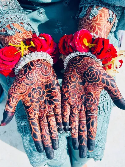The contrast between the red flowers and the deep henna stain is just beautiful. This is the kind of photo-ready result I aim for with every client.