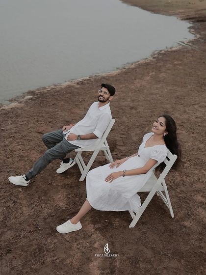 A minimalist and artistic shot of the couple relaxing in chairs by the lakeside on an overcast day.