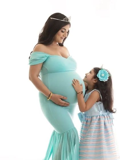 A sweet moment between a mother-to-be and her daughter, who looks up lovingly at the baby bump. This family maternity photo beautifully captures the bond between them.