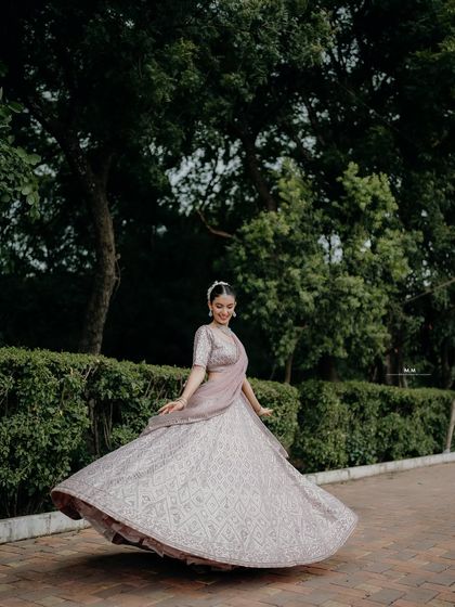 A joyful twirl in a beautiful lehenga. This shot captures the movement and elegance of the outfit, as well as the bride's happy spirit.