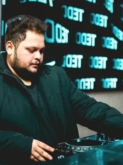 Focused on the mix, syncing heartbeats through sound. A close-up of me working the turntables against a backdrop of my logo.