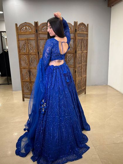 The back view of the blue lehenga, featuring a stylish deep-back blouse design that adds a modern touch.