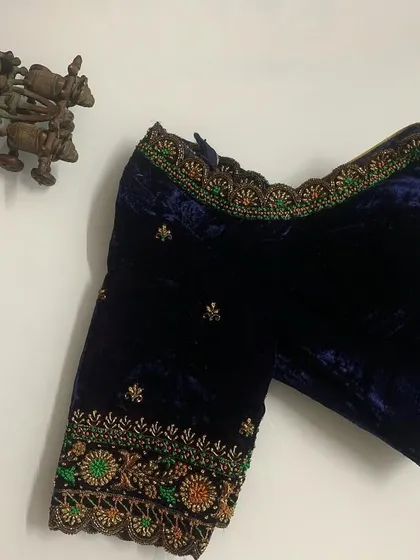 Another view of the custom navy blue velvet blouse. The detailed embroidery on the sleeves adds a pop of color and intricate texture.