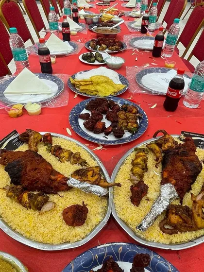 This is our specialty, the Dastarkhwan setup for a grand wedding feast. We arrange long tables with a full spread of starters, salads, and our famous Mandi-style biryani platters featuring whole roasted chicken, ready for the guests to arrive.
