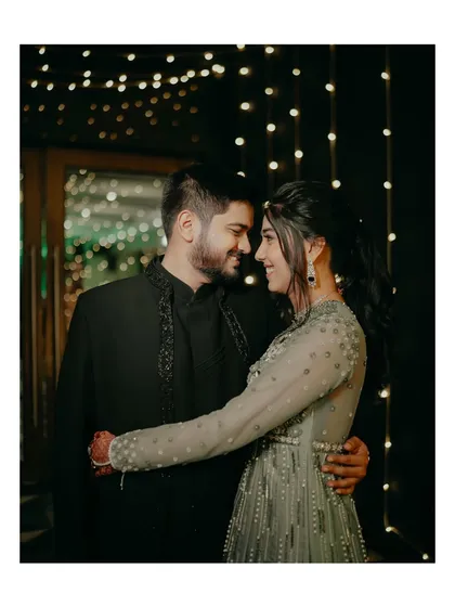 A classic romantic portrait from the Sangeet night. The couple embraces under the soft glow of fairy lights, lost in a moment of quiet intimacy amidst the celebration.