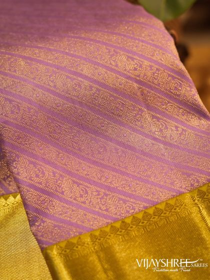 A close-up of the intricate zari stripes on the lavender Kanjivaram, showcasing the fine craftsmanship.