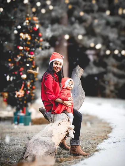 A magical, AI-enhanced Christmas portrait. We photographed this mother and daughter in our studio and then placed them in a dreamy, snowy forest with a decorated tree.