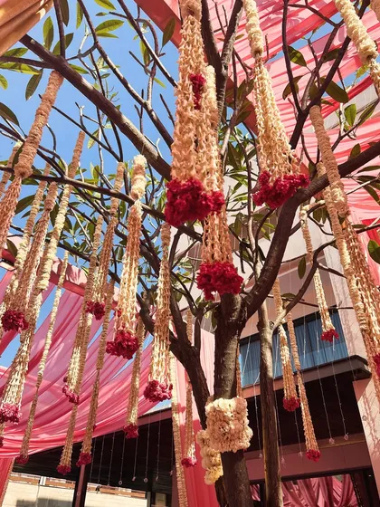 For this ceremony, we hung beautiful floral tassels made of jasmine and roses from the trees, creating a fragrant and visually delicate canopy over the seating area.