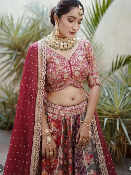 A close-up of the floral print lehenga, showing the rich colors and detailed embroidery on the blouse. It's a piece of wearable art.