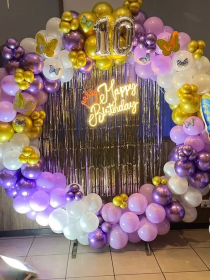A detailed view of the butterfly ring backdrop, showing the '10' foil balloons for a 10th birthday.