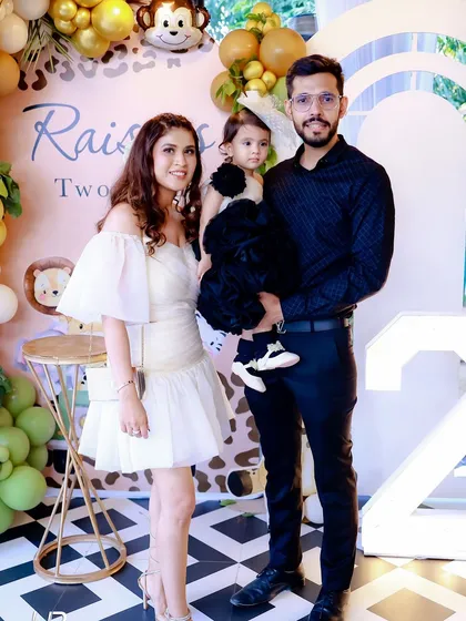 The birthday girl with her parents at the "Two Wild" party. The custom backdrop and marquee number light create a beautiful setting for capturing family memories.