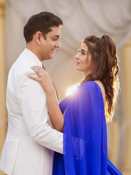 A beautiful sun-kissed shot from a 25th-anniversary shoot. The makeup is radiant and glowing, perfectly complementing her royal blue gown.