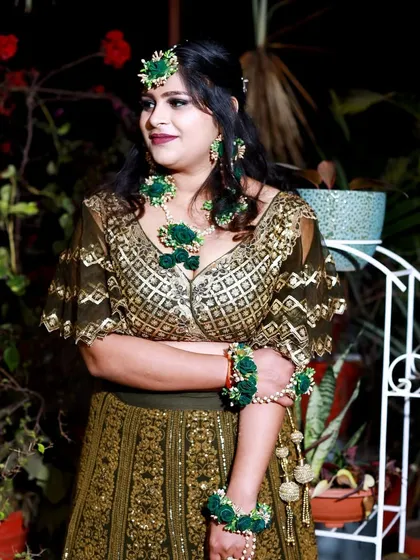 A candid portrait of the bride, looking elegant and happy. The focus is on her beautiful floral jewelry and the joy of the occasion.
