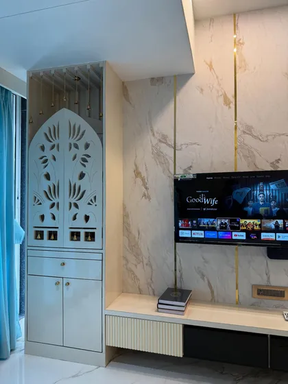 A detailed view of the pooja unit with its intricate jaali-cut doors, placed next to the modern TV console. This highlights my ability to blend spiritual spaces with contemporary home design.