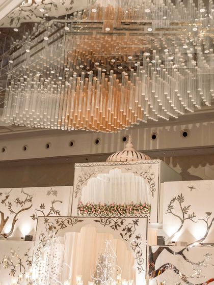 A detailed shot of the double-decker entrance structure, showing the intricate mirror work and the upper jharokha-style window where performers were stationed. The design blends traditional motifs with modern spectacle.