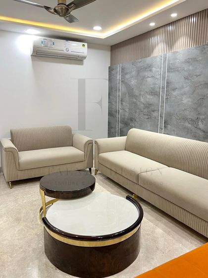 Another angle of this living room, showing the pairing of the two-seater and three-seater sofas. The nested coffee tables with their contrasting tops serve as a central focal point.