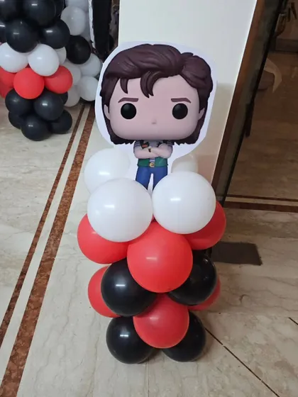 A Funko Pop style character cutout from our 'Stranger Things' theme, placed on a custom balloon stand.